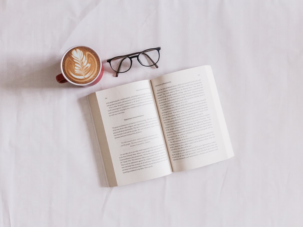 book near eyeglasses and cappuccino