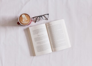 book near eyeglasses and cappuccino