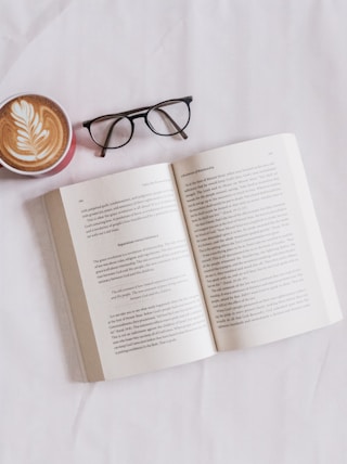 book near eyeglasses and cappuccino