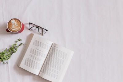 book page beside eyeglasses and coffee