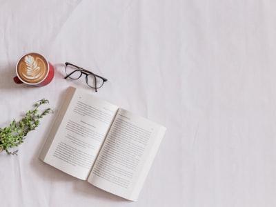 book page beside eyeglasses and coffee book google meet background