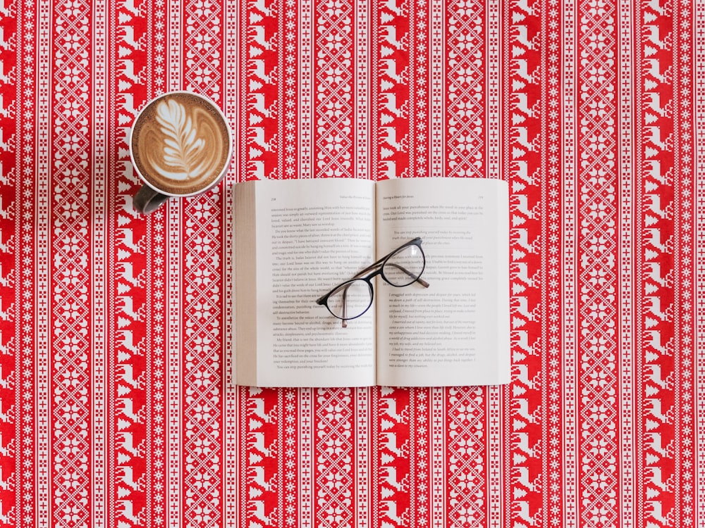 Brille mit schwarzem Rahmen oben auf dem Buch