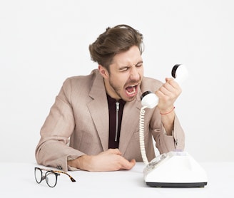 man holding telephone screaming