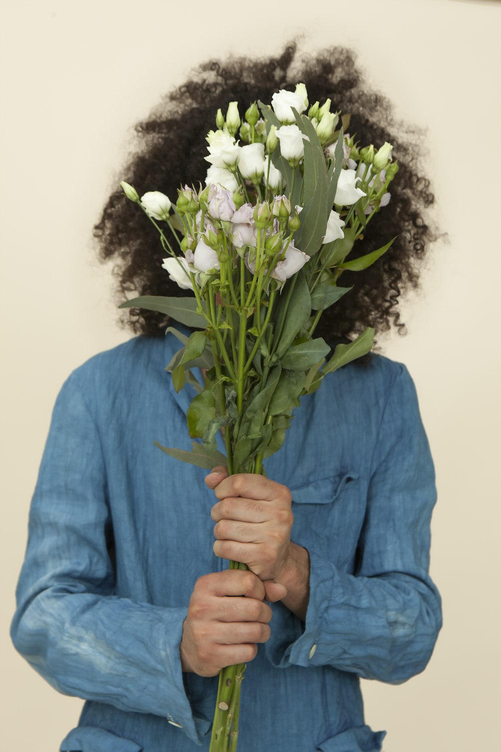 흰색 튤립 꽃다발을 들고 있는 사람의 선택적 초점 사진