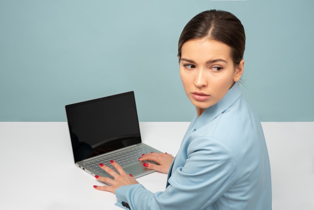 donna che usa il computer portatile e guardando il lato