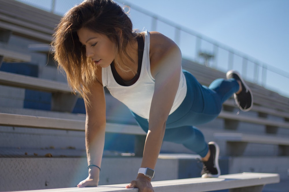 selective focus photography of woman doing planking on bench