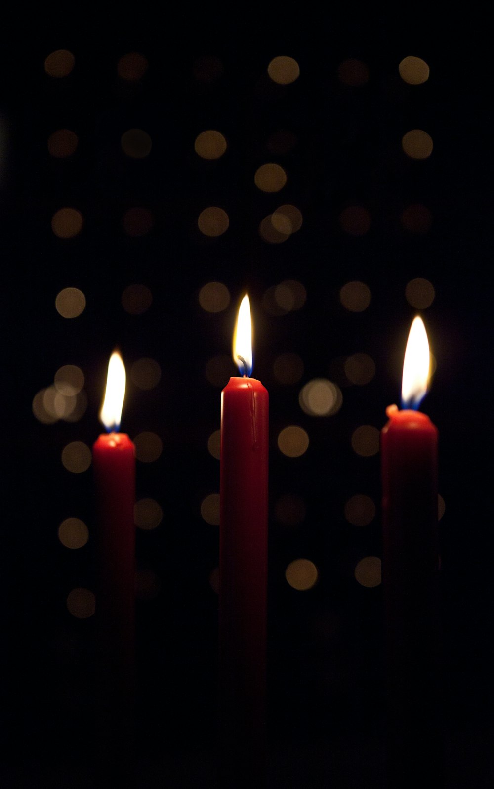 three lighted red candlesticks