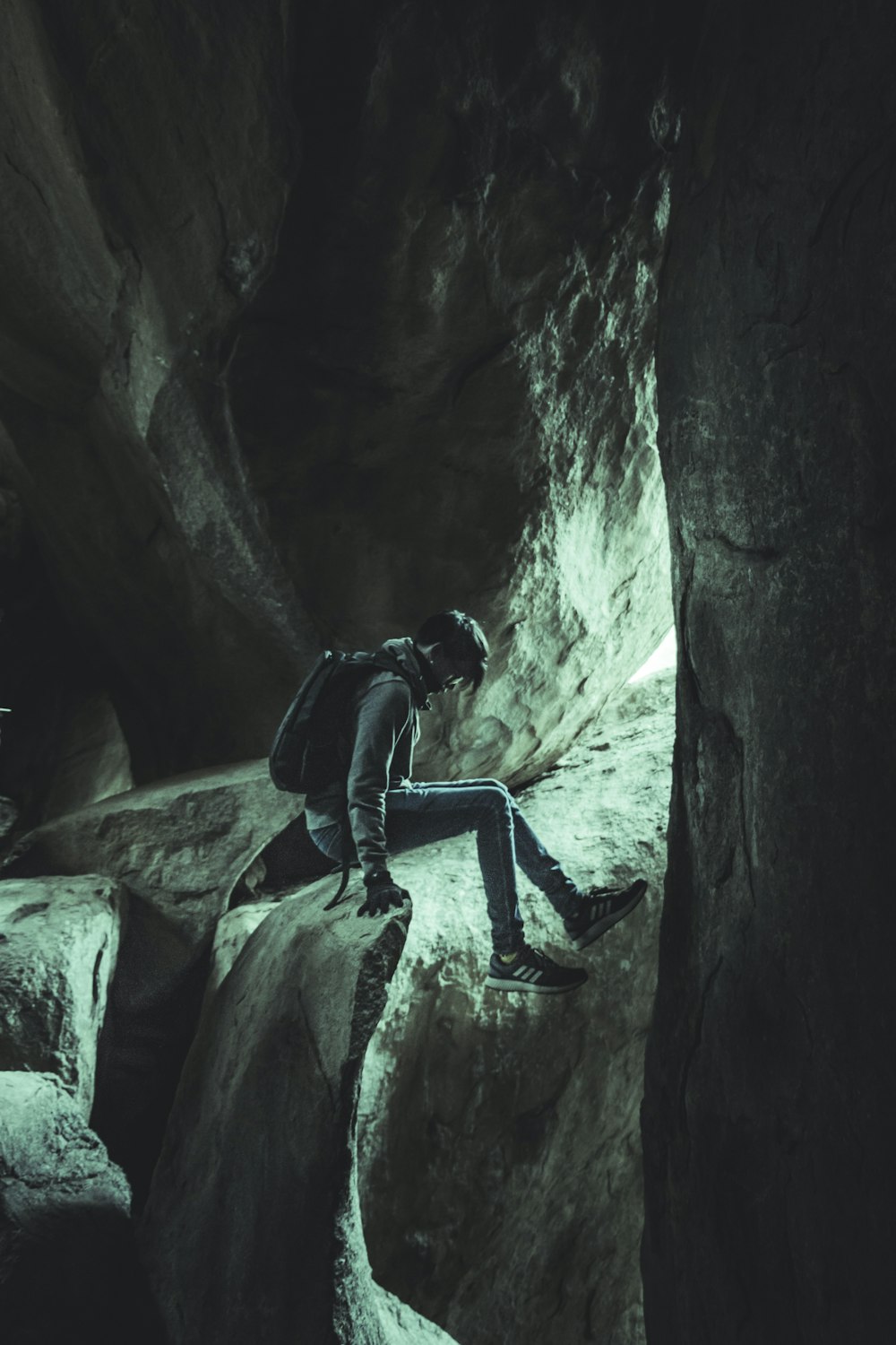 man climbing on brown rock painting