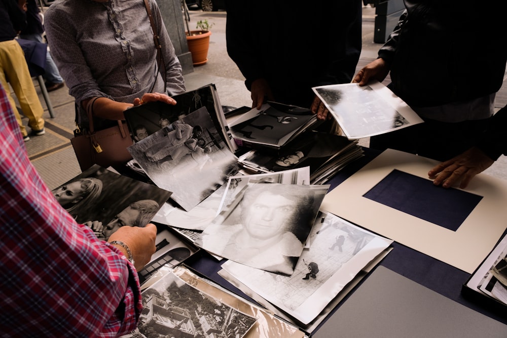 people standing near table holding photos