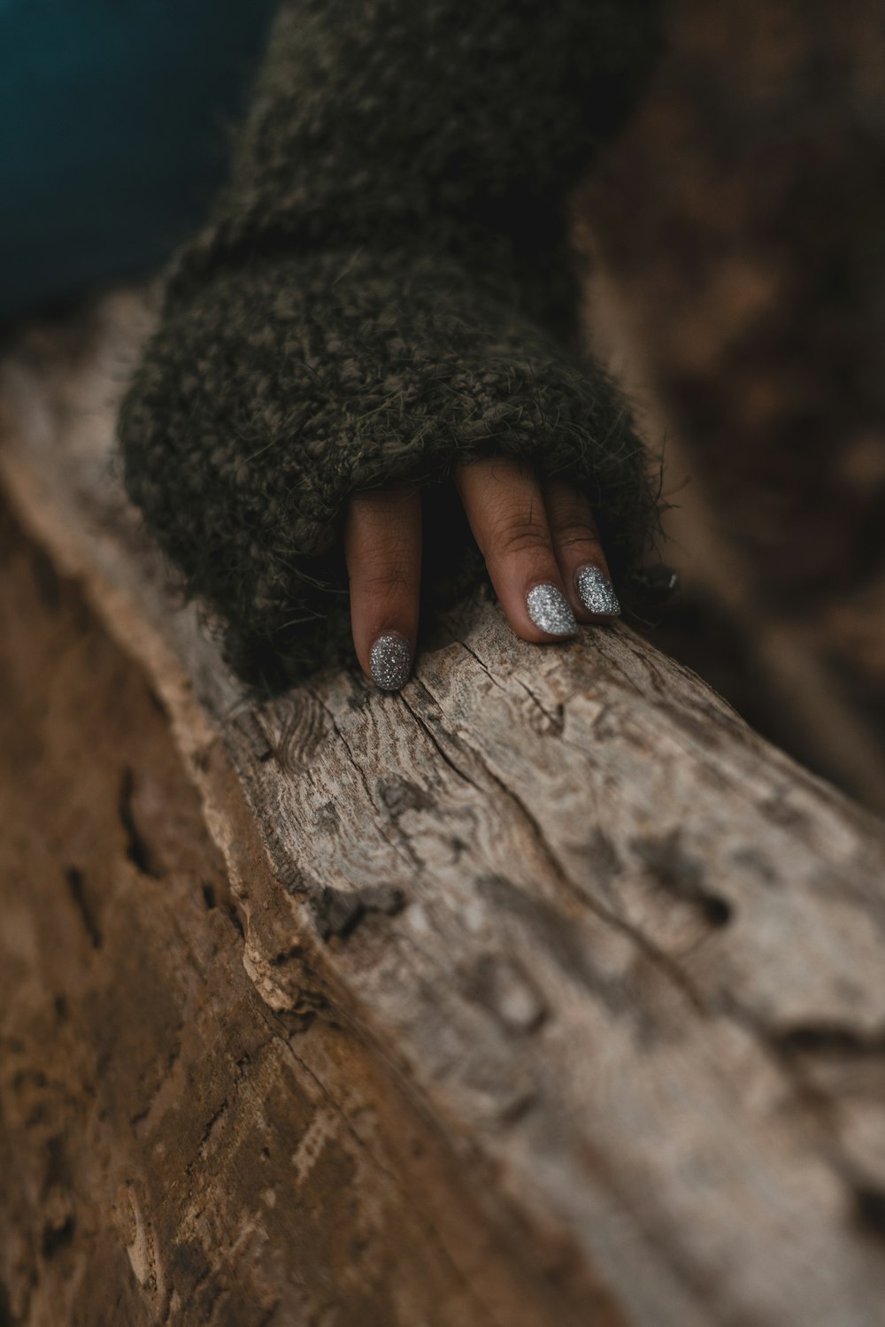 a person's hand resting on a log