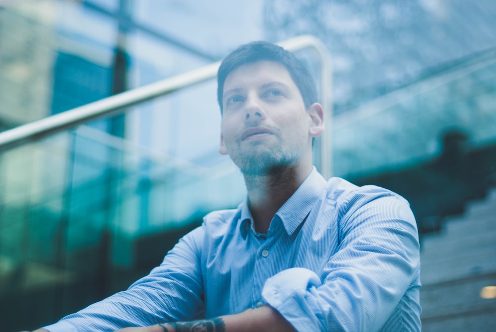 selective focus photography of man wearing blue dress shirt