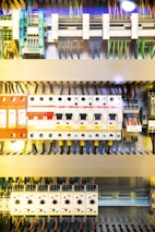 A detailed view of an electrical control panel displaying various circuit breakers, wiring, and switches. The panel includes colored wires and labeled components organized systematically.