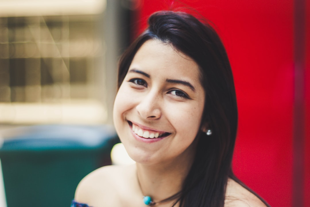 smiling woman wearing blue necklace