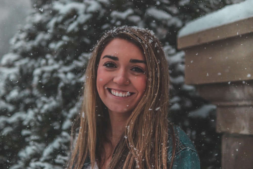 smiling woman wearing gray sweater during winter