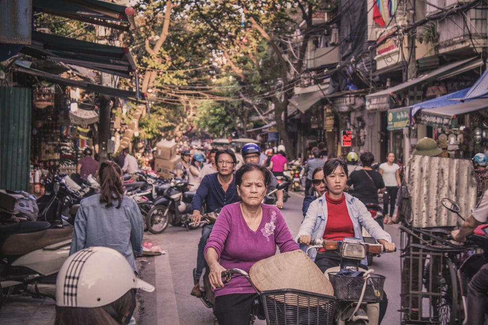 people riding motorcycles and bicycles on street during daytime