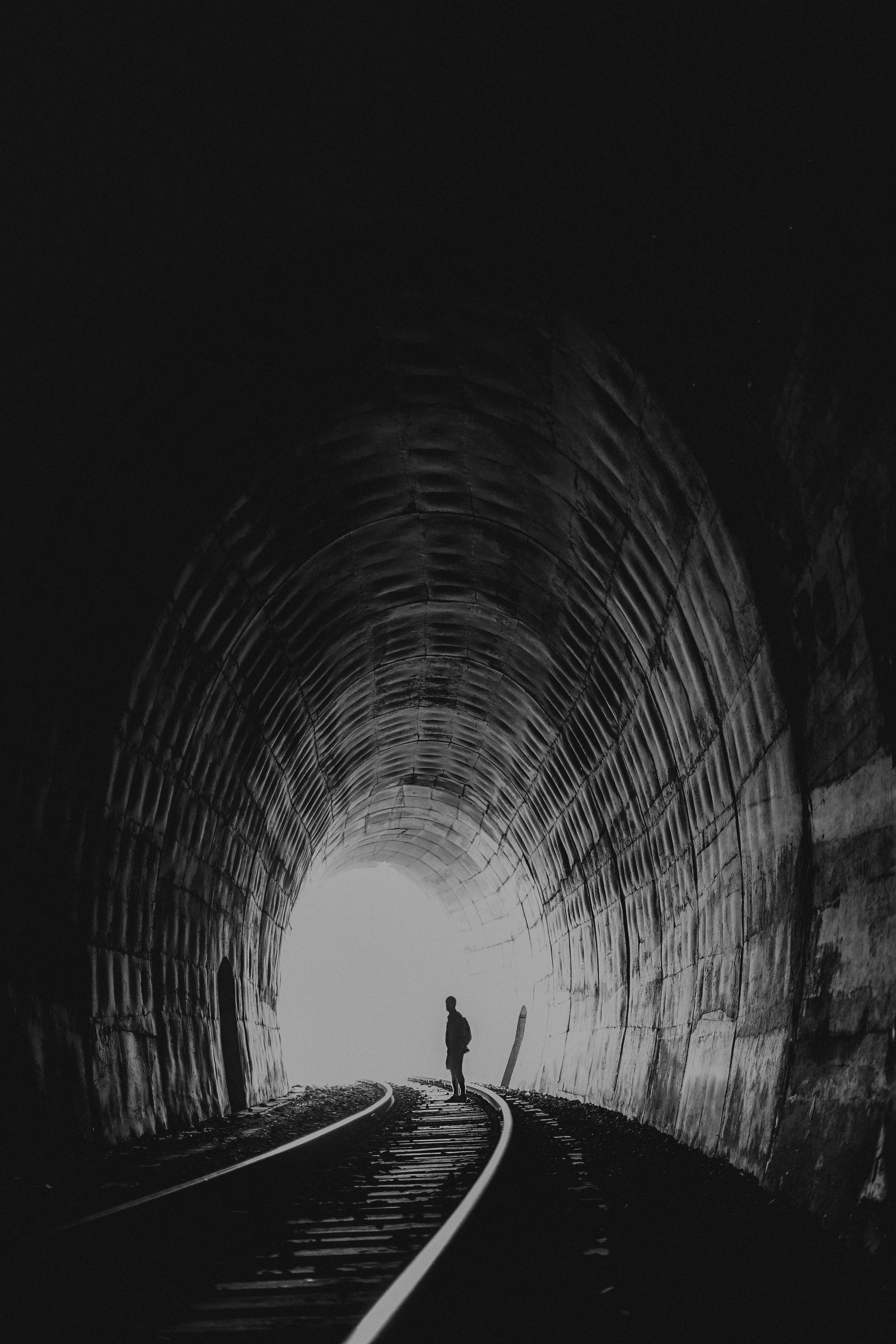 Person standing in between road photo Free Grey Image on Unsplash