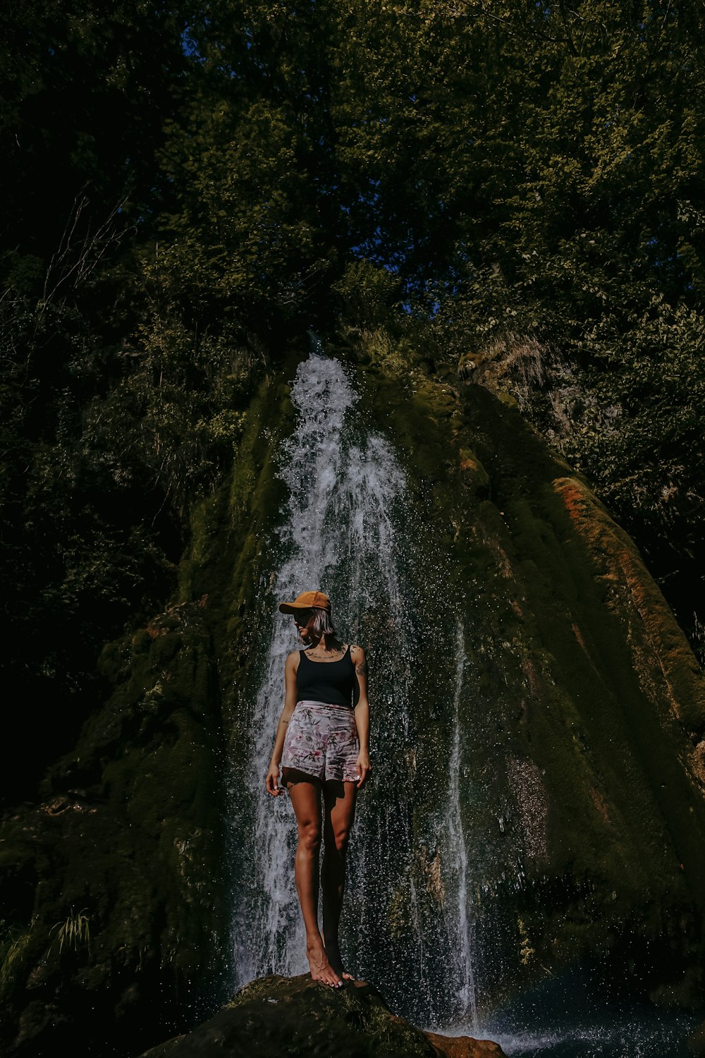 woman standing beside waterfalls