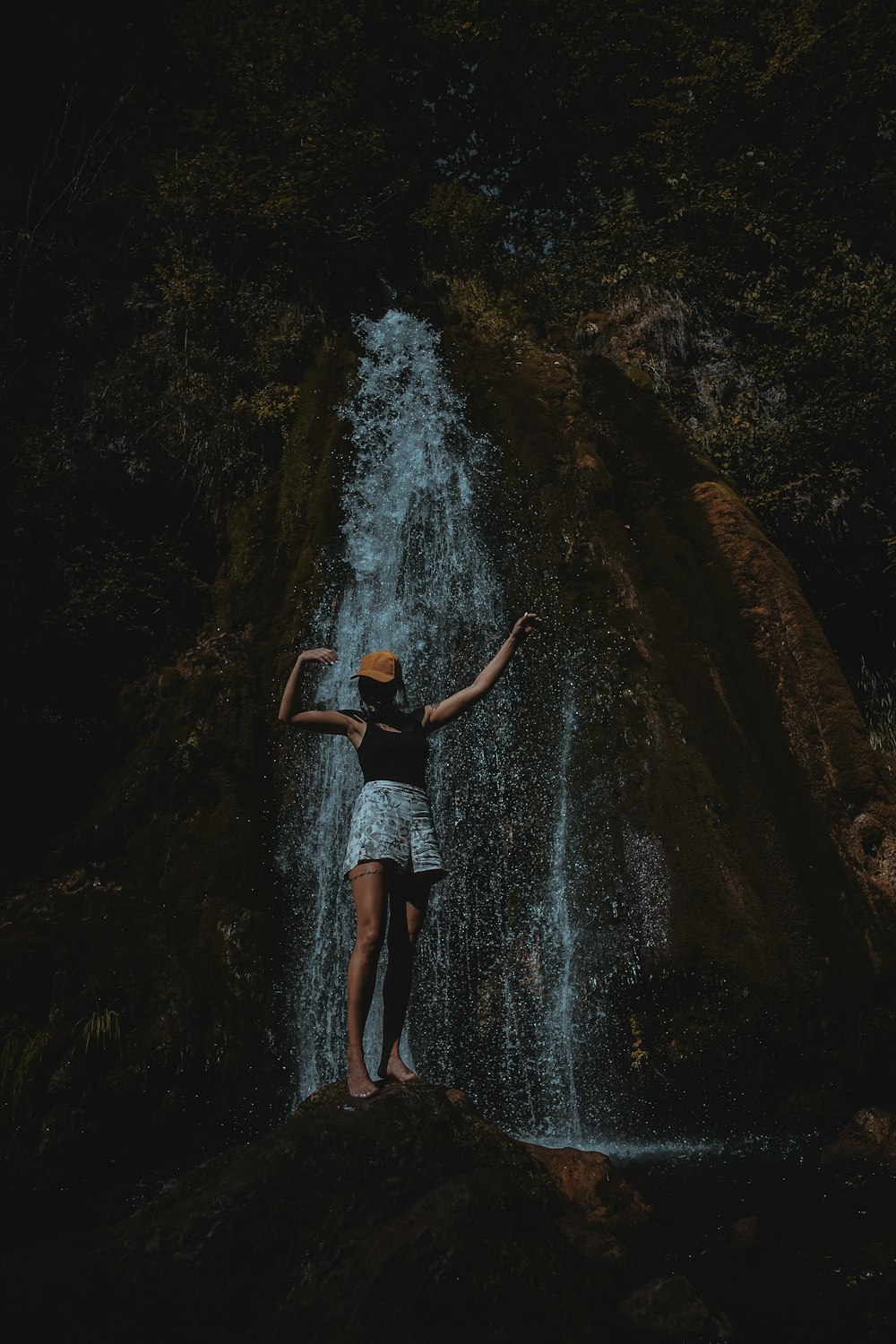 woman standing beside waterfalls