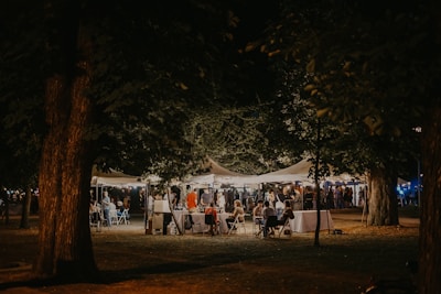 Evening event under a spacious tent with ambient lighting and decorated tables.