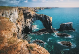 gray and brown rock formation and mountain near body of water
