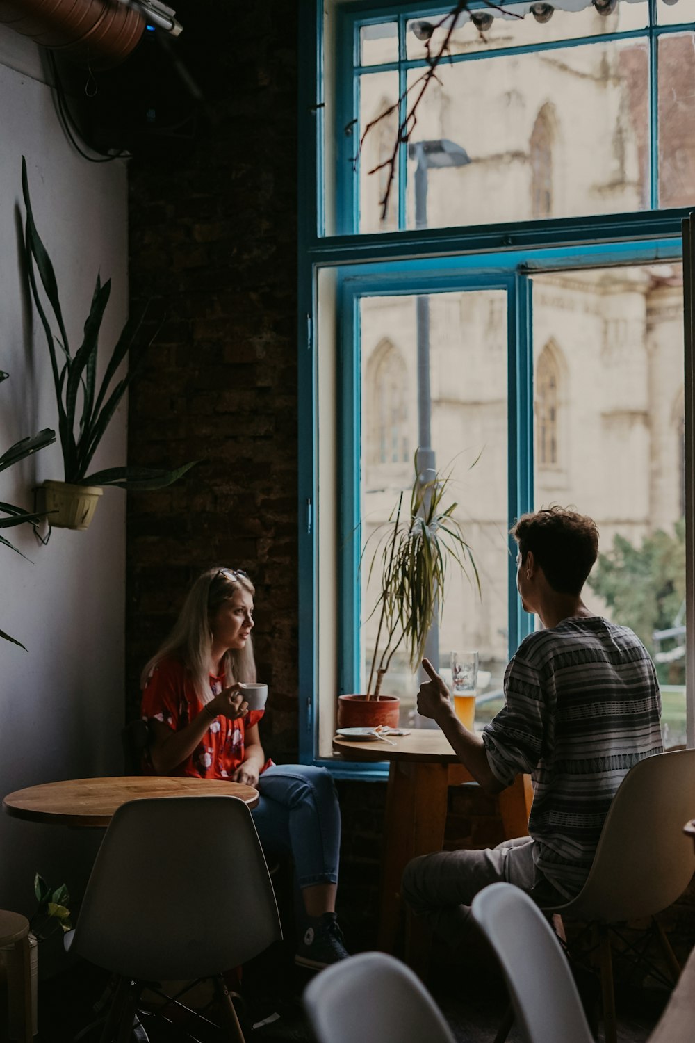 man and woman in front of round brown wooden pedestal table