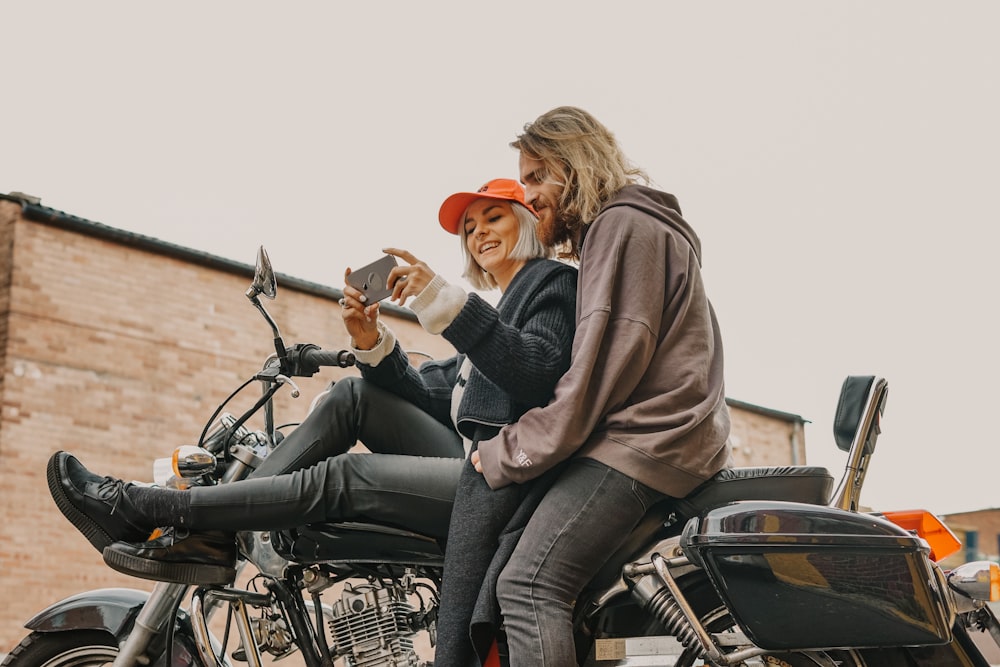 man hugging woman watching in her smartphone