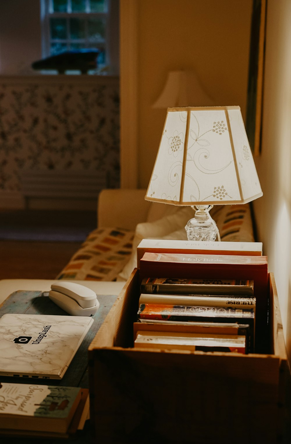 lighted table lamp beside books