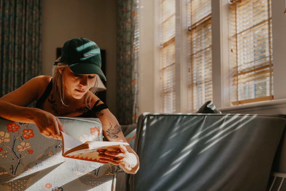 woman wearing black tank top holding book