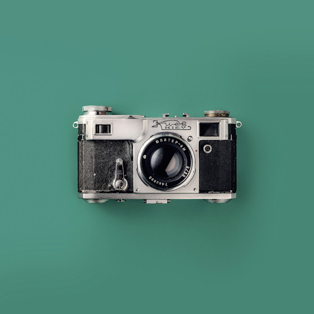 silver SLR camera on teal background