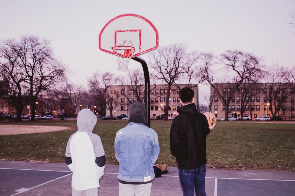 three men standing on basketball court