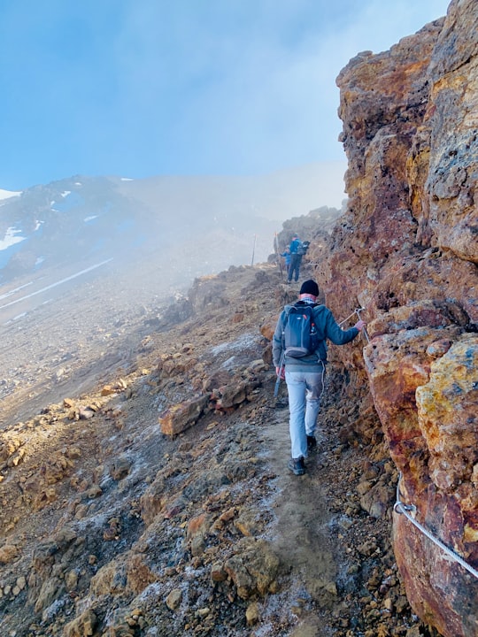 two men walking rocky mountain in Tongariro Alpine Crossing New Zealand