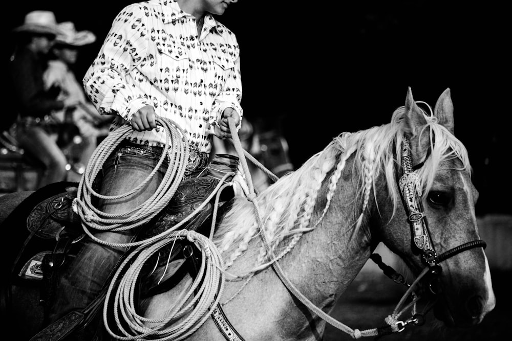 grayscale photography of man riding horse