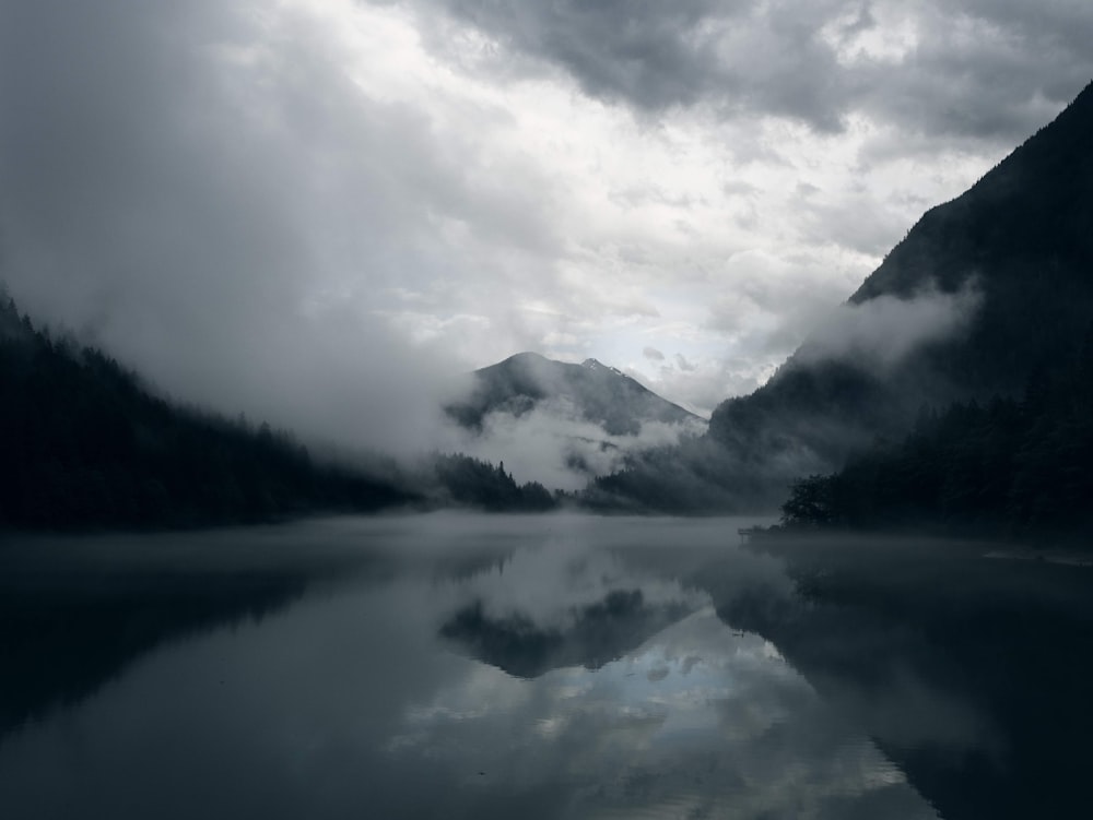 calm body of water near mountains