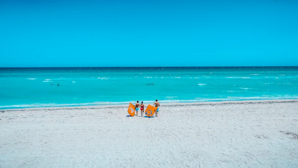 A happy family lounging on brisamar towels by the sparkling ocean shore.