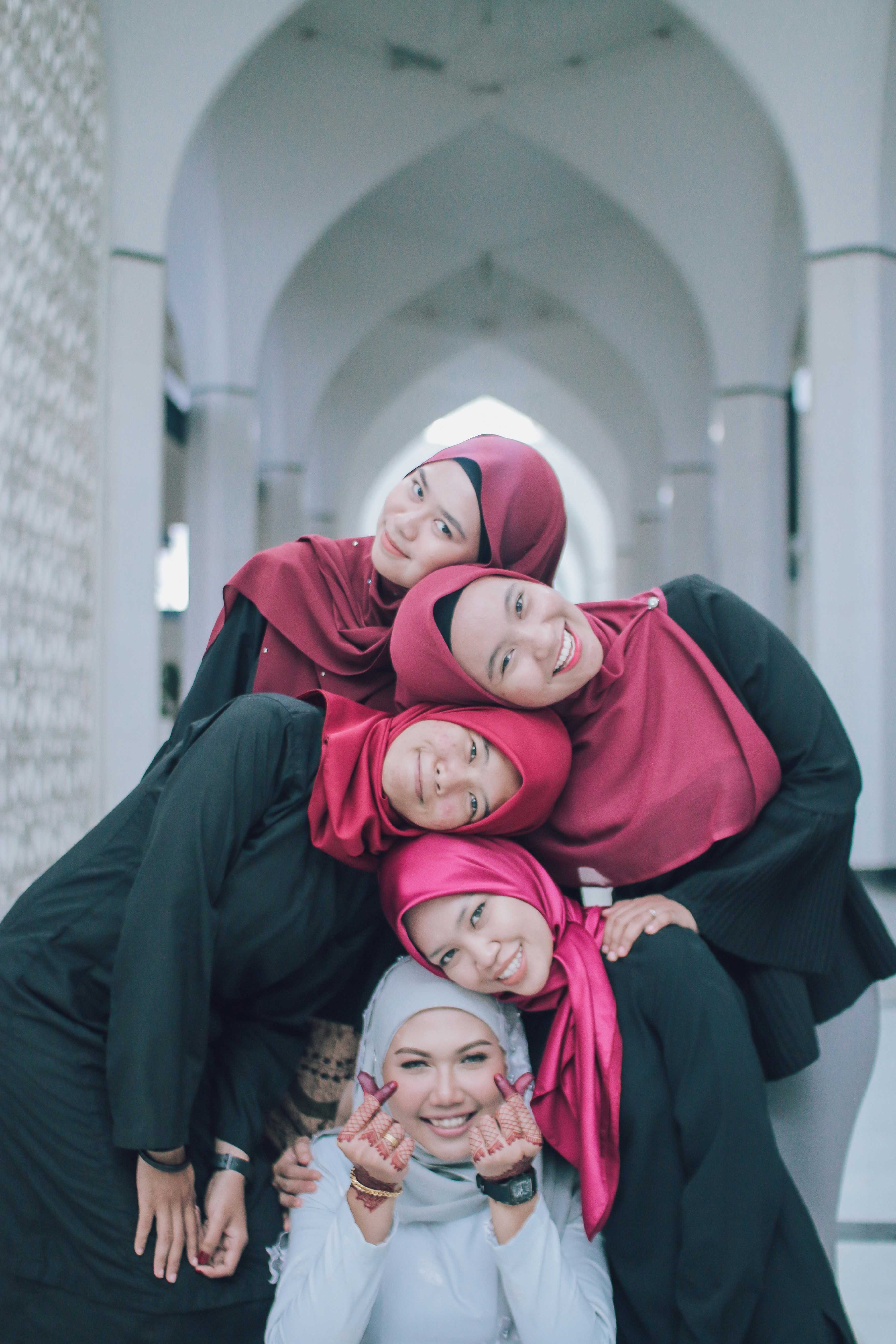 lima wanita mengenakan jilbab saling bersandar