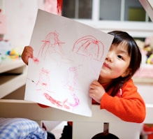 girl holding paper with drawing