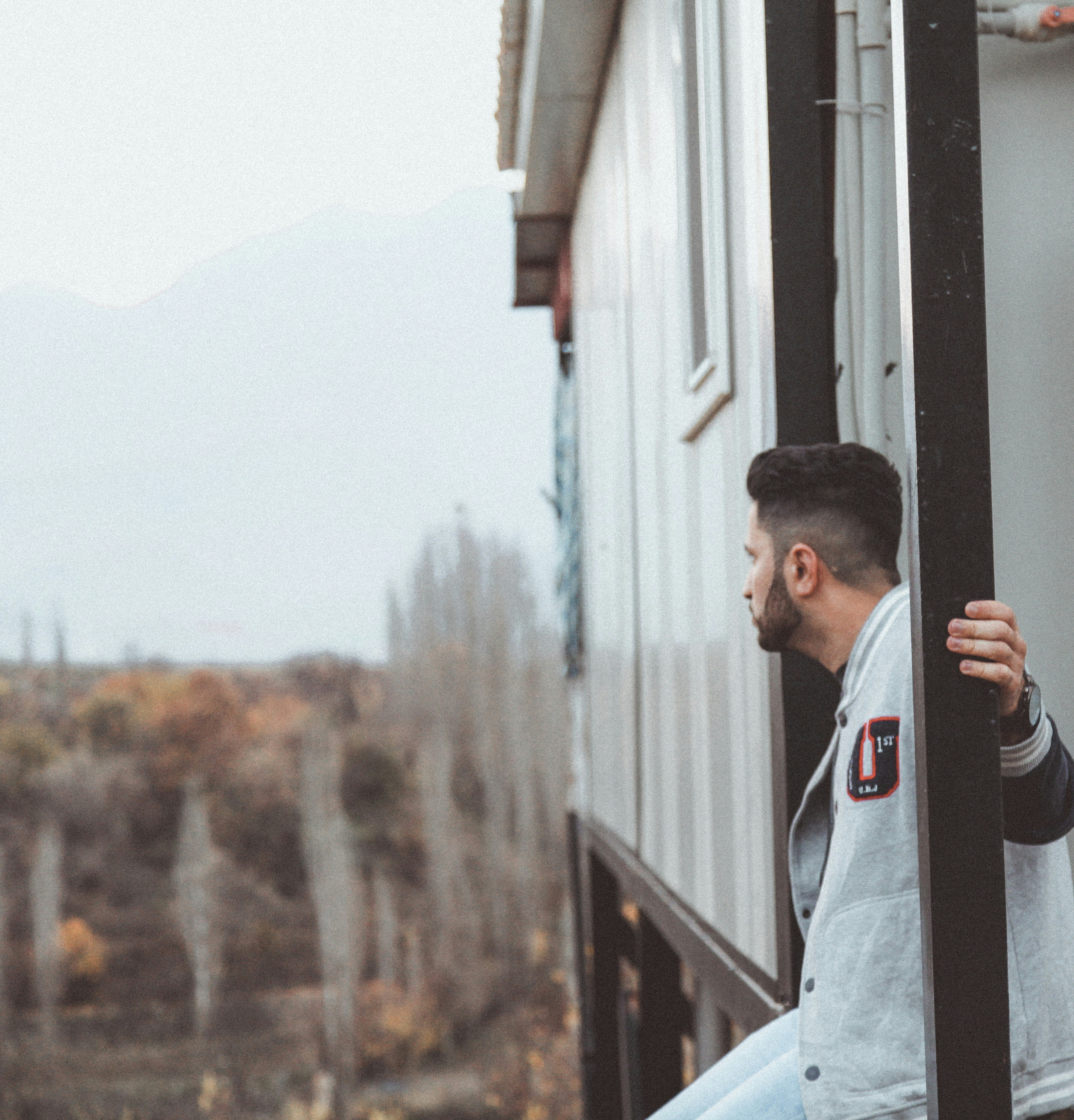 man standing beside house