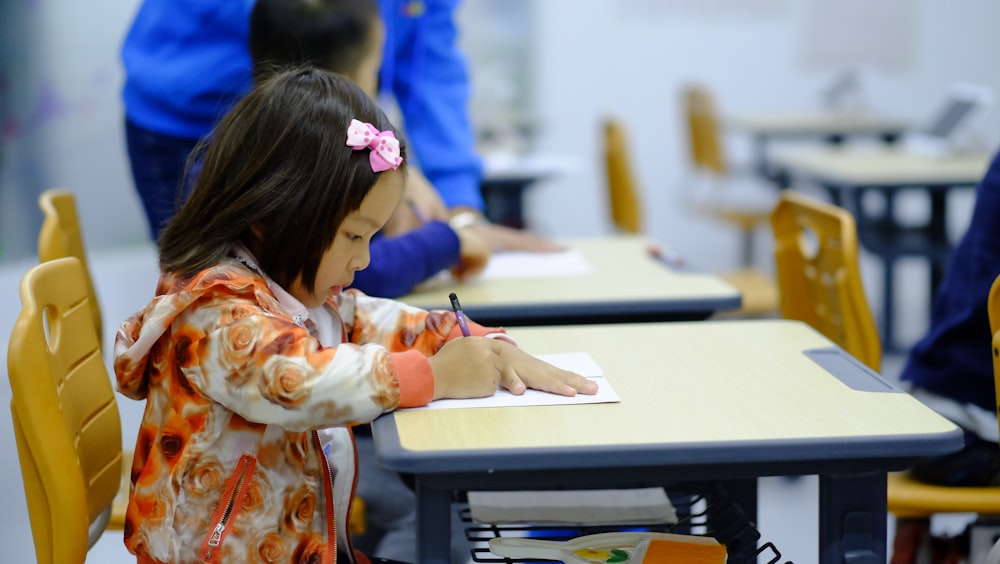 enfant en bas âge assis sur le bureau