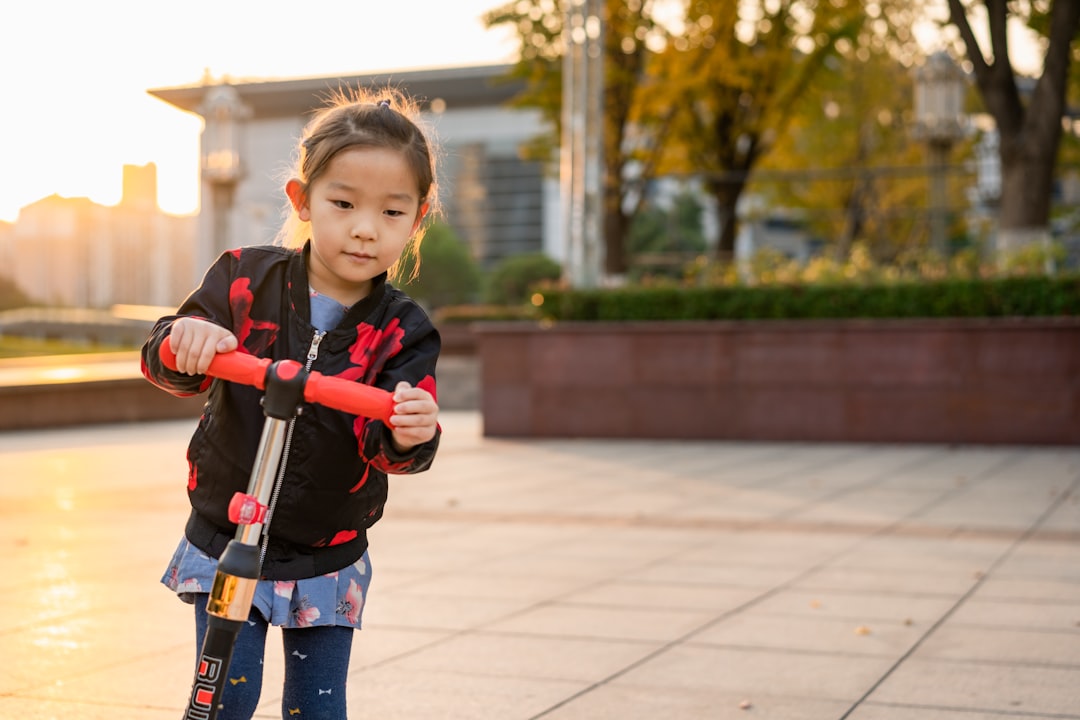 girl playing kick scooter outside the house