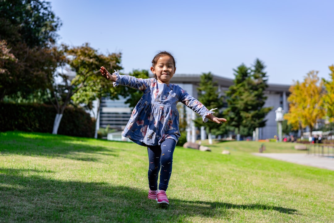 toddler running in grass field