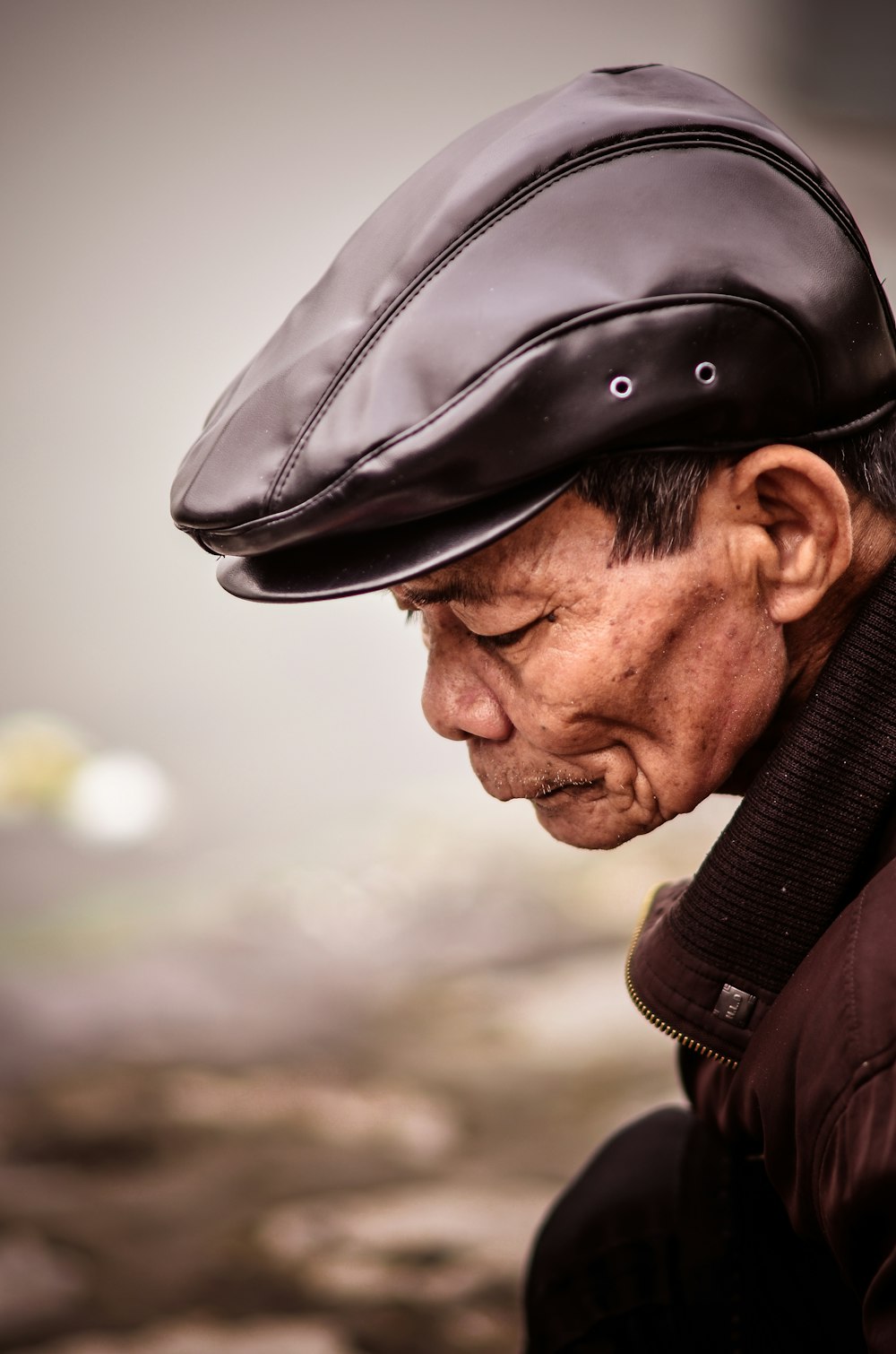 man wearing brown jacket with black hat