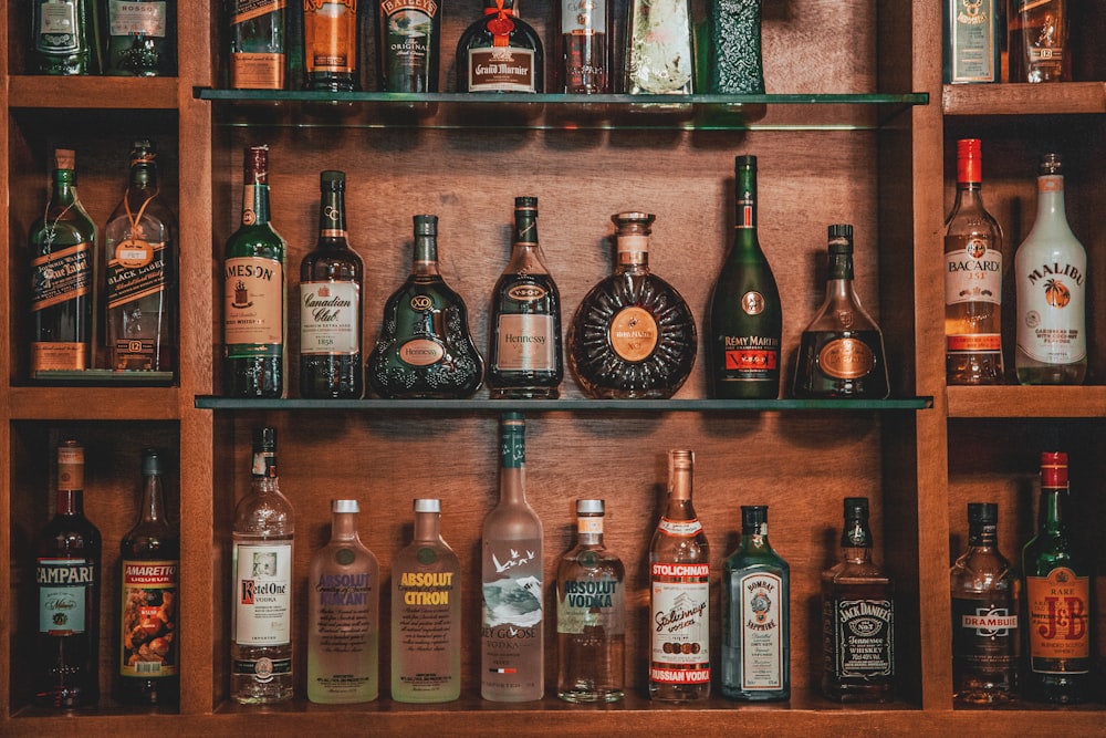 assorted liquor on brown wooden shelf