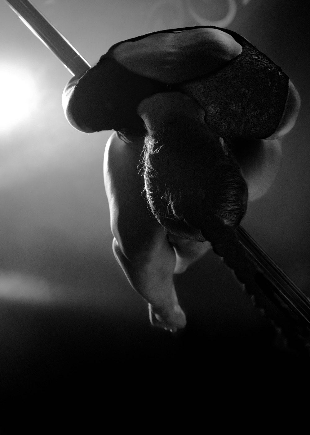 Photographie en niveaux de gris d’une femme faisant de la pole dance