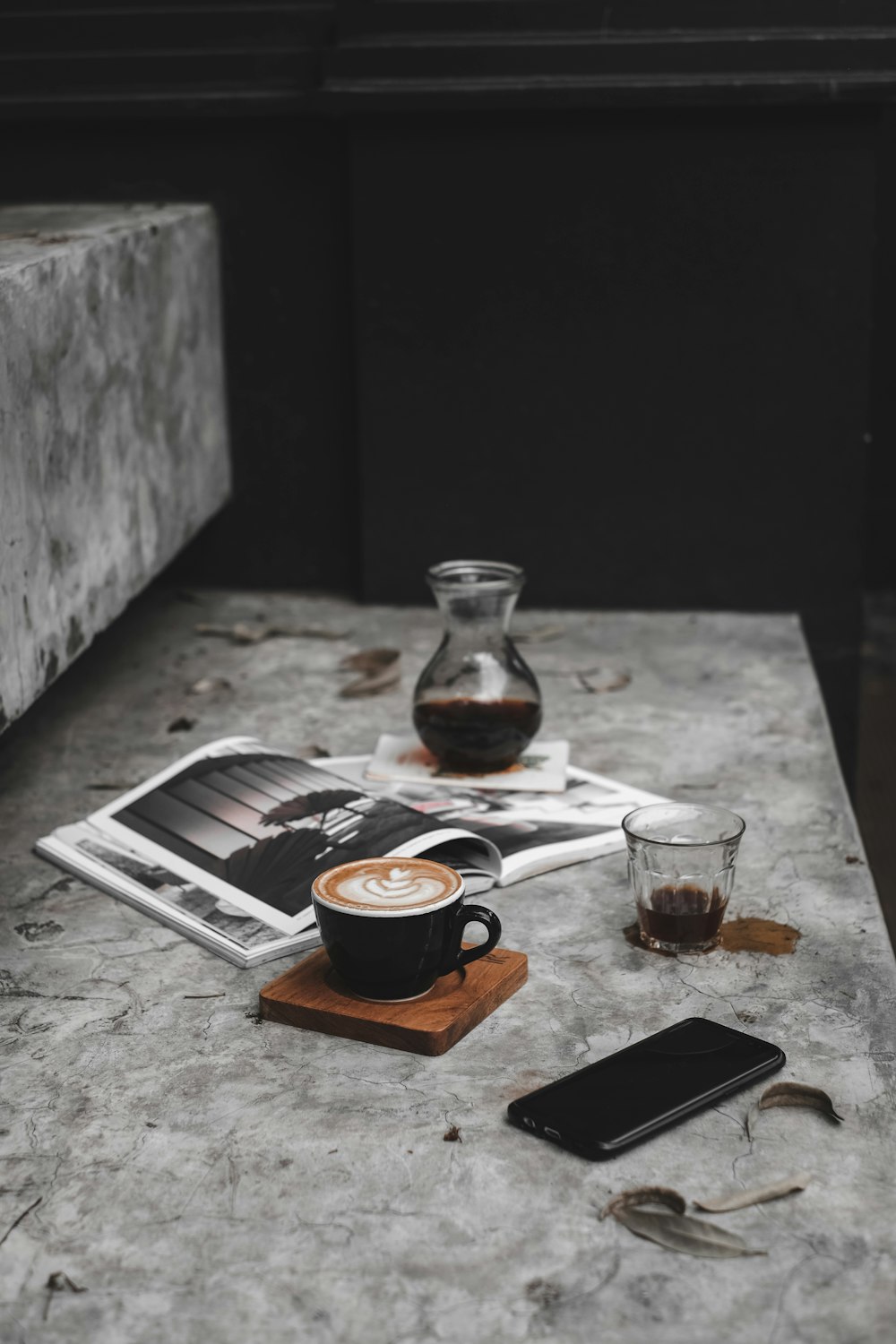 cup of rosetta art latte beside smartphone