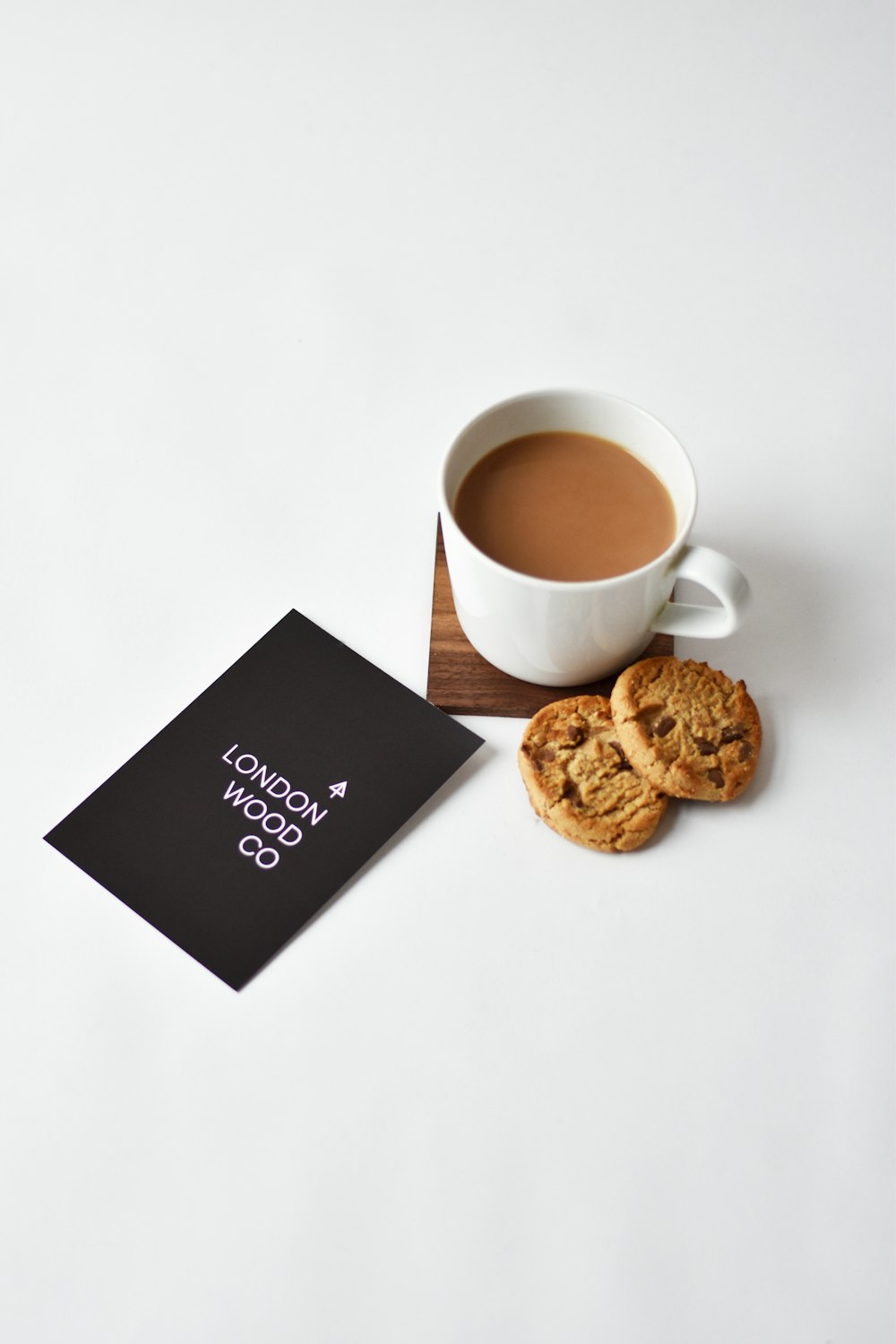 white ceramic cup on brown wooden coaster