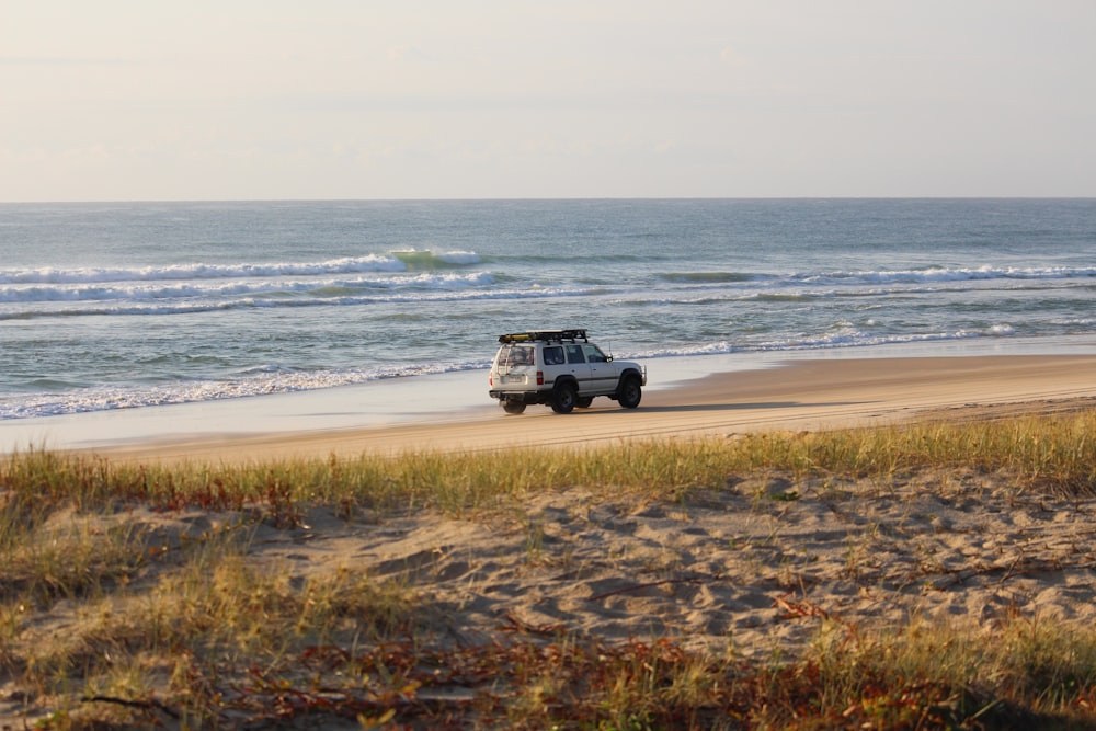 white vehicle beside seashore during daytime