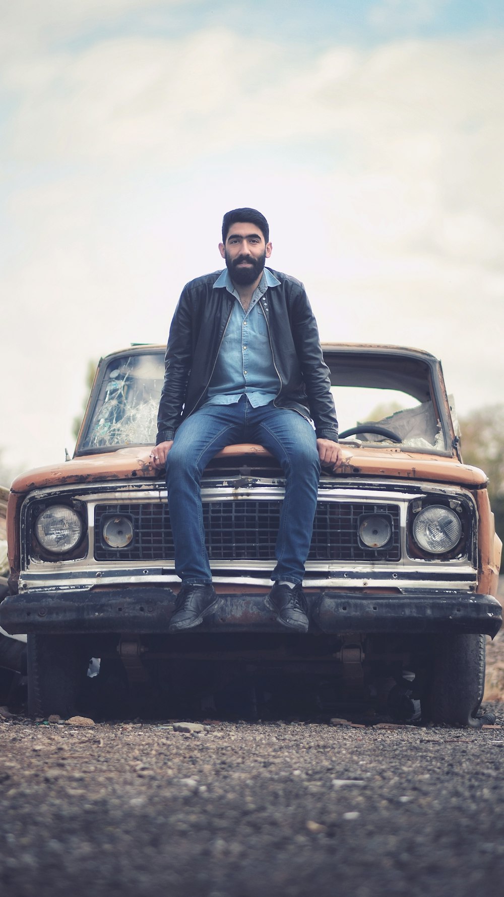 man sitting on car hood