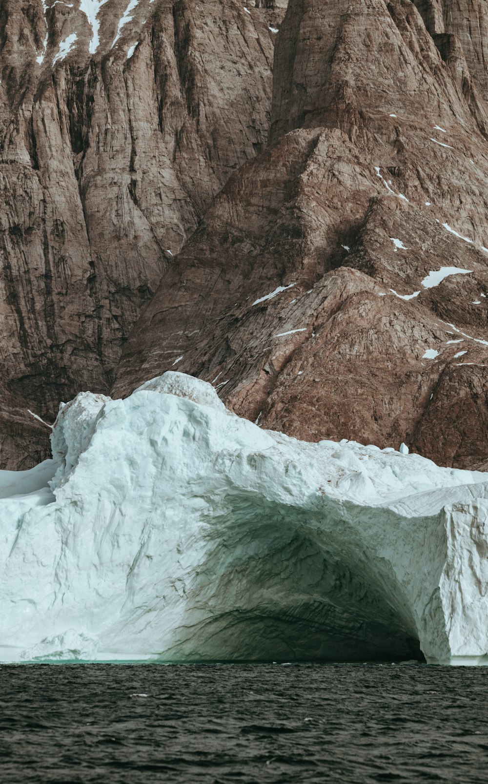 iceberg beside mountain and sea