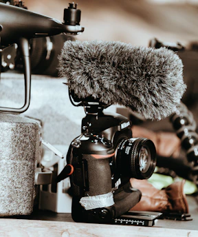 A sleek camera and microphone kit arranged neatly on a wooden desk.