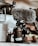 A professional camera equipped with a large, furry microphone is positioned on a surface. Surrounding items include components of a drone and some indistinct background elements, adding a tech-focused atmosphere.